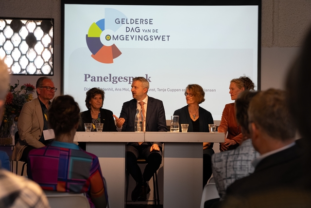 Foto van het panel gezeten achter een brede tafel op de Gelderse Dag van de Omgevingswet.